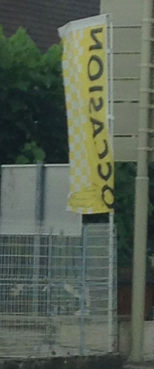 Drapeau OCCASION bandes latérales jaune format professionnel Bannière OCCASION jaune à bandes latérales ondulant sur parc de véhicules d'occasion en concession automobile